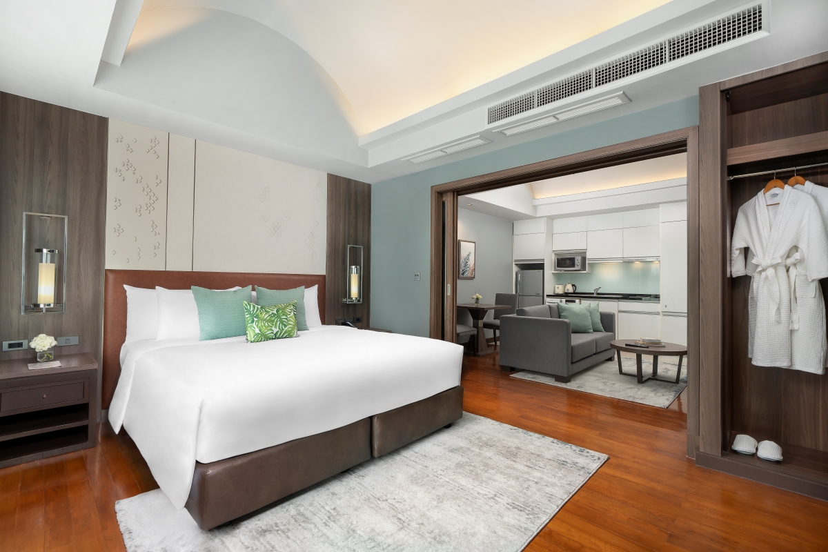 Suite Comfort Room with a king-size bed, separate living area, elegant furnishings, and premium amenities at Novotel Living Bangkok Sukhumvit Legacy.