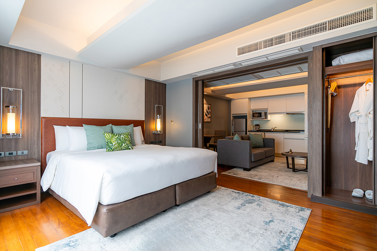 Suite Comfort Room with a king-size bed, separate living area, elegant furnishings, and premium amenities at Novotel Living Bangkok Sukhumvit Legacy.