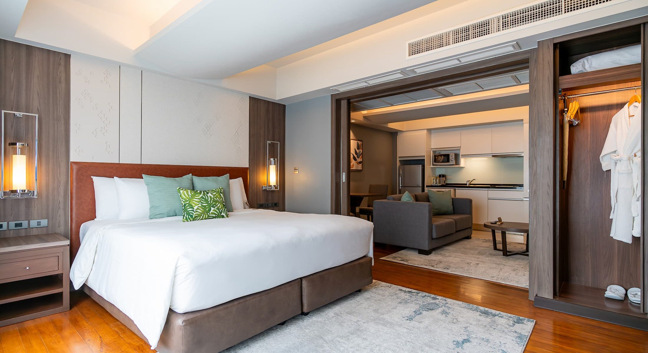 Suite Comfort Room with a king-size bed, separate living area, elegant furnishings, and premium amenities at Novotel Living Bangkok Sukhumvit Legacy.
