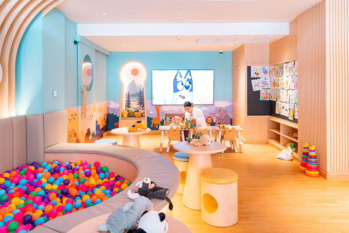 A vibrant and engaging kids' play area at Playtopia, Novotel Living Bangkok Sukhumvit Legacy, featuring a ball pit, activity tables, and a cozy reading nook.